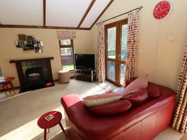 A living room with a sofa and television at Riverside Lodge 3