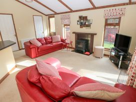 A living room with a sofa and television at Riverside Lodge 3