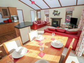A living room with a dining table and sofa at Riverside Lodge 3