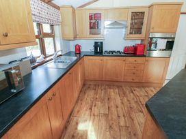 A kitchen with cabinets and appliances at Riverside Lodge 3
