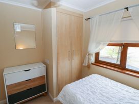 A bedroom with a bed, wardrobe, and mirror at Riverside Lodge 3