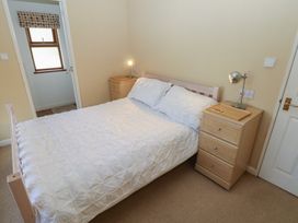 A bedroom with a bed and nightstand at Riverside Lodge 3