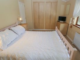 A bedroom with a bed, wardrobe, and television at Riverside Lodge 3