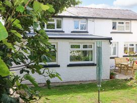 A garden with a house and furniture at Coach House Cottage in 