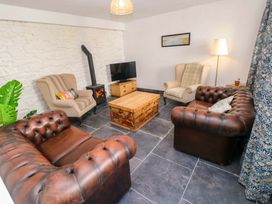 A living room with a coffee table and sofas at Coach House Cottage