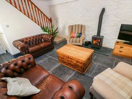 A living room with a fireplace and two sofas at Coach House Cottage
