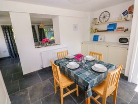 A dining room with a table set for meals at Coach House Cottage