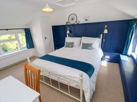 A bedroom with a bed and desk at Coach House Cottage