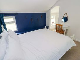 A bedroom with a bed and a desk at Coach House Cottage