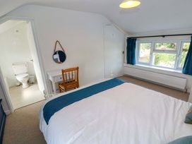A bedroom with a bed and a window at Coach House Cottage 