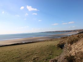 A beach view with cliffs and ocean at Coach House Cottage