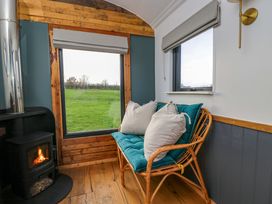 A living room with a sofa and a fireplace at Wiltshire Weavers Hut in Sutton Benger near Christian Malford