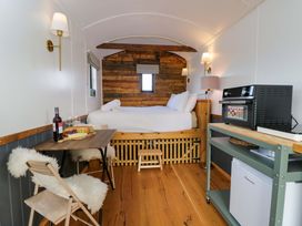 A bedroom with a bed and dining table at Wiltshire Weavers Hut Sutton Benger near Christian Malford