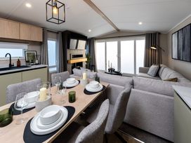 A dining area with a table set for dinner and a sofa at Arlington 40 x 14 Two Bed