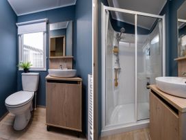 A bathroom with a toilet, basin, and shower at Arlington 40 x 14 Two Bed