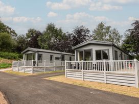 Two mobile homes with decking and fenced areas at The Pines 2 Bedrooms Delamere