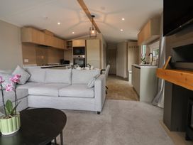A living room with a sofa and coffee table at The Pines 2 Bedrooms in Delamere