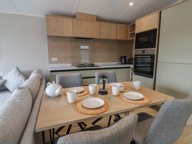 A kitchen with a dining table set for tea at The Pines 2 Bedrooms Delamere