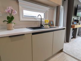A kitchen with a sink and flower pot at The Pines 2 Bedrooms Delamere