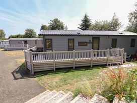 A mobile home with a deck in an outdoor setting at The Pines 2 Bedrooms Delamere