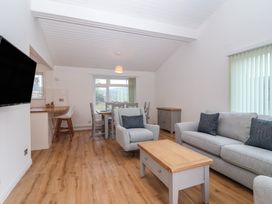 A living room with a sofa and dining table at Harcombe House Bungalow 25 in Chudleigh