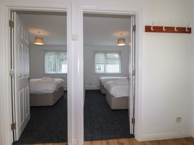 A view of two bedrooms with beds and windows at Harcombe House Bungalow 25 Chudleigh