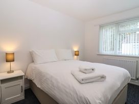 A bedroom with a bed and bedside lamp at Harcombe House Bungalow 25 Chudleigh