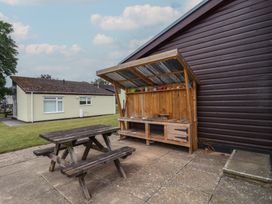 An outdoor area with a picnic table and wooden shelter at Harcombe House Bungalow 25 Chudleigh