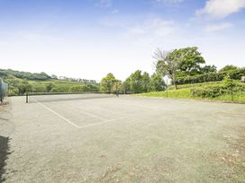 A tennis court surrounded by greenery at Harcombe House Bungalow – Pet Friendly with Wet Room Chudleigh