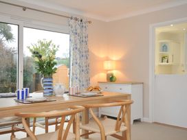 A dining room with a table and flowers at 42 Little Trelyn Rock