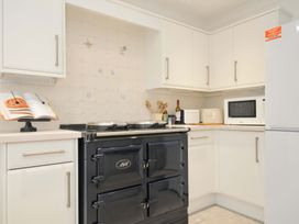 A kitchen with a black stove and microwave at 42 Little Trelyn in Rock