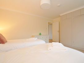 A bedroom with twin beds and storage at 42 Little Trelyn Rock