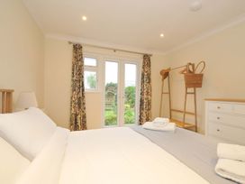 A bedroom with a bed and windows at 42 Little Trelyn in Rock