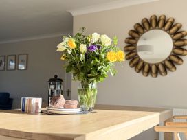 A kitchen with a flower vase and French press on a table at 42 Little Trelyn in Rock