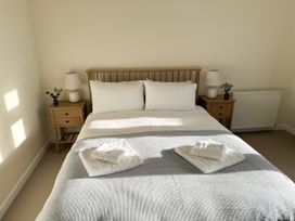 A bedroom with a bed and bedside tables at 42 Little Trelyn in Rock