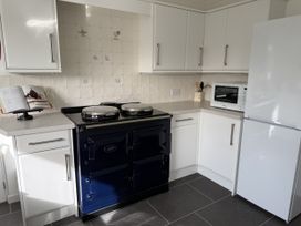 A kitchen with a blue cooker and microwave at 42 Little Trelyn Rock