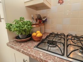 A kitchen countertop with a basil plant and a bowl of lemons at Iveridge Sandsend