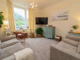 A living room with a television and seating at Zide the Zea, Hele Bay, Ilfracombe