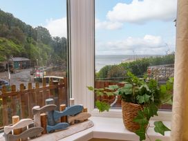 A window view with fish decor and a plant at Zide the Zea in Hele Bay, Ilfracombe