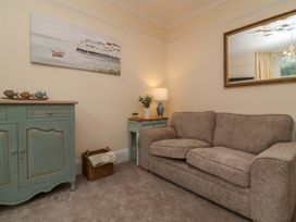 A living room with a sofa, side table, and lamp at Zide the Zea in Hele Bay, Ilfracombe