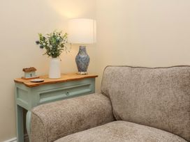 A living room with a sofa and table lamp at Zide the Zea in Hele Bay, Ilfracombe