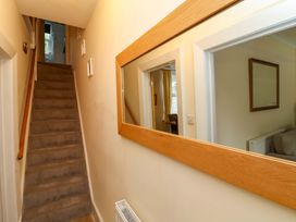 A hallway with a staircase and mirror at Zide the Zea in Hele Bay, Ilfracombe