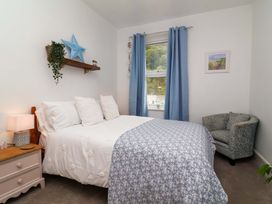 A bedroom with a bed and an armchair at Zide the Zea in Hele Bay, Ilfracombe