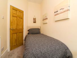 A bedroom with a bed and wall art at Zide the Zea, Hele Bay, Ilfracombe