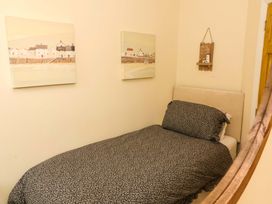 A bedroom with a bed and paintings on the wall at Zide the Zea, Hele Bay, Ilfracombe
