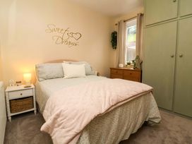 A bedroom with a bed and nightstand at Zide the Zea, Hele Bay, Ilfracombe