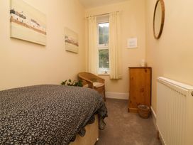 A bedroom with a bed, chair, and window at Zide the Zea in Hele Bay, Ilfracombe