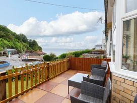 An outdoor seating area with chairs and a table at Zide the Zea in Hele Bay, Ilfracombe