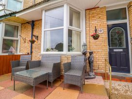 An outdoor seating area with armchairs and a coffee table at Zide the Zea, Hele Bay, Ilfracombe