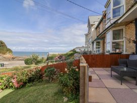 An outdoor seating area with flowers and ocean view at Zide the Zea, Hele Bay, Ilfracombe